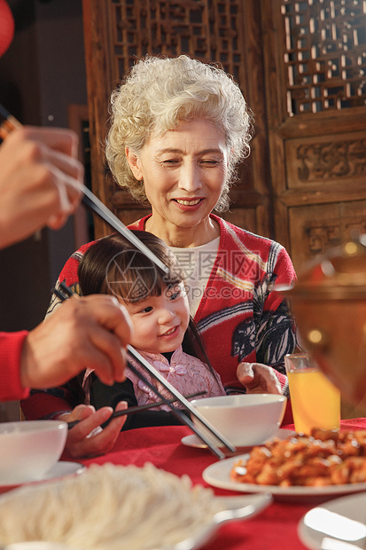 餐桌上抱着孙女的祖母图片