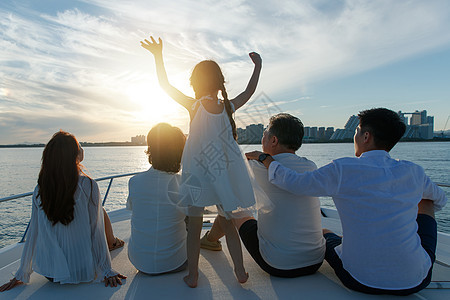 夕阳下坐在游艇上的快乐一家人图片