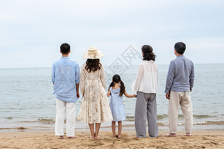 快乐的一家人站在海滩上图片