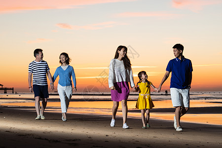 夕阳海景夕阳下在海边散步的幸福家庭背景