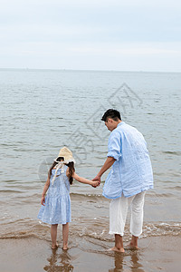 海滩背影快乐父女在海边玩耍背景
