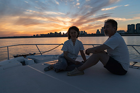 夕阳海景老年夫妇乘坐游艇背景