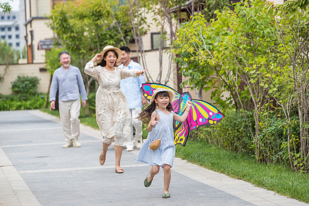 风筝和小女孩拿着风筝的小女孩和家人在户外玩耍背景