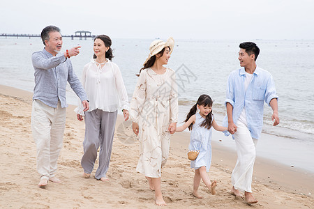 一家人在沙滩快乐的一家人在海滩上散步背景