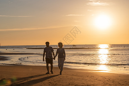 老年夫妇在海边散步背景