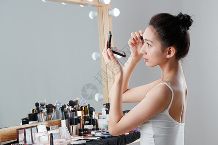 美女照镜子年轻女人在化妆间里化妆背景