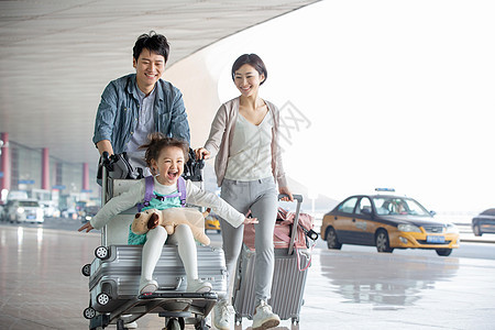 快乐家庭推着行李在机场图片