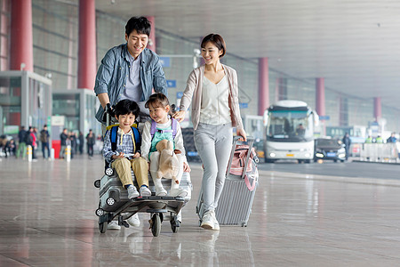 快乐家庭推着行李在机场图片