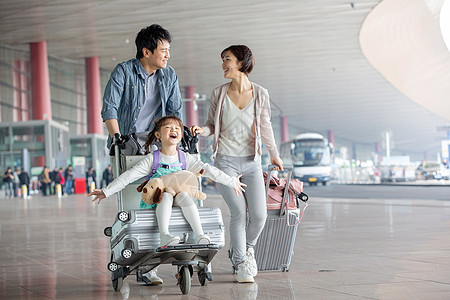快乐家庭在机场推着行李图片