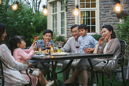 阳台院子快乐大家庭在庭院里用餐背景