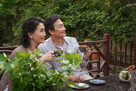 老年夫妇坐在院子里喝茶背景