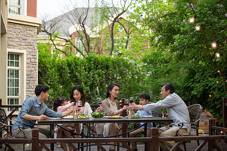 快乐大家庭在庭院里用餐图片