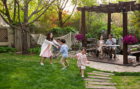 快乐家庭在庭院里玩耍高清图片