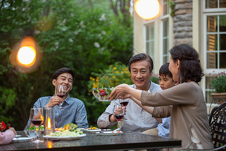 孩子吃饭快乐大家庭在庭院里用餐背景