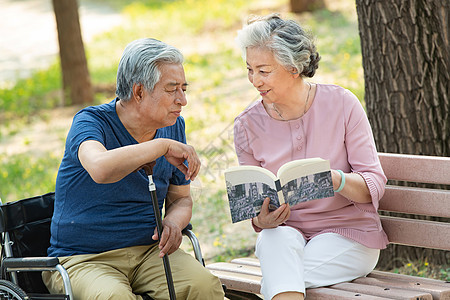 老年夫妇坐在公园里看书图片