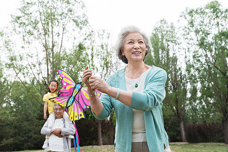 老年夫妇带着孙女在公园里放风筝图片