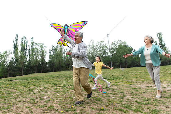 老年夫妇带着孙女在公园里放风筝图片