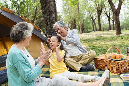 老年夫妇带着孙女在公园里郊游祖母高清图片素材