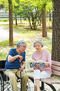 老年夫妇坐在公园里看书图片