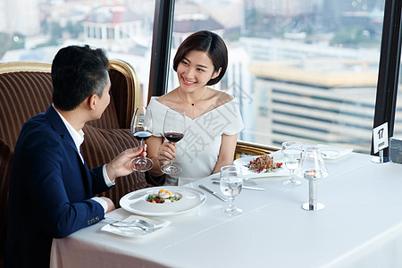 穿红礼服女人青年夫妇在餐厅用餐背景