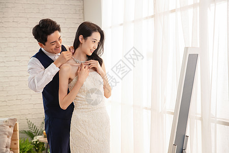 年轻男士帮妻子戴项链高清图片
