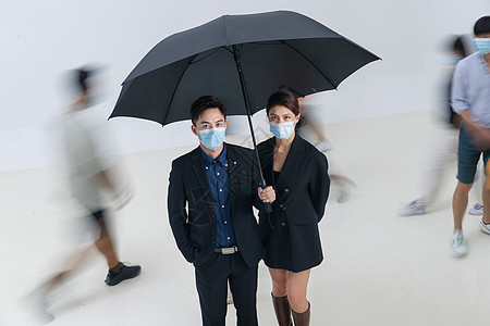 拿着雨伞的商务男女戴着口罩站在人群中图片