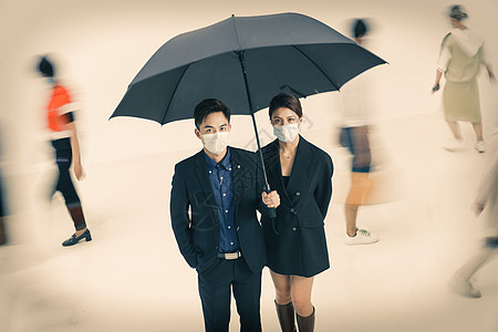 拿着雨伞的商务男女戴着口罩站在人群中图片