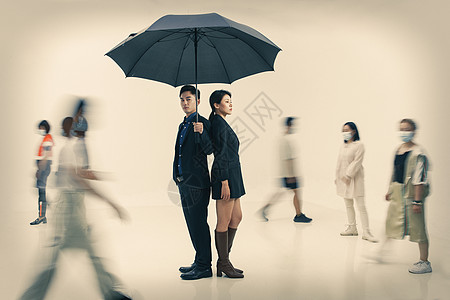 拿雨伞的情侣拿着雨伞的商务男女站在人群中背景
