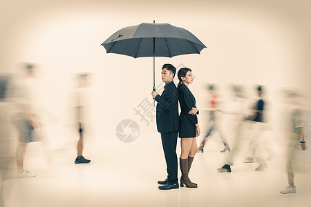 拿着雨伞的商务男女站在人群中图片素材