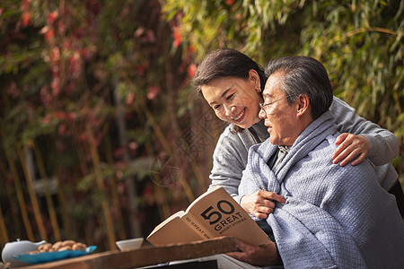 幸福的老年夫妇在户外看书高清图片