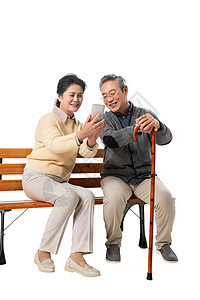 老年夫妇坐在长椅上看手机图片