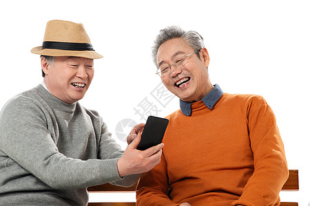 打电话的老人两位老年朋友坐在长椅上看手机背景