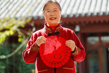 老年女人手拿窗花庆祝新年高清图片