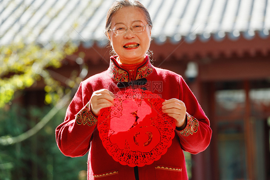 老年女人手拿窗花庆祝新年图片