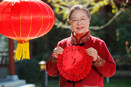 老年女人手拿窗花庆祝新年图片