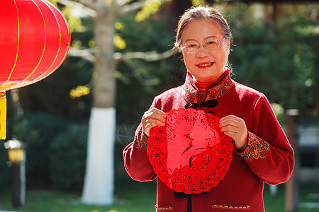 老年女人手拿窗花庆祝新年图片