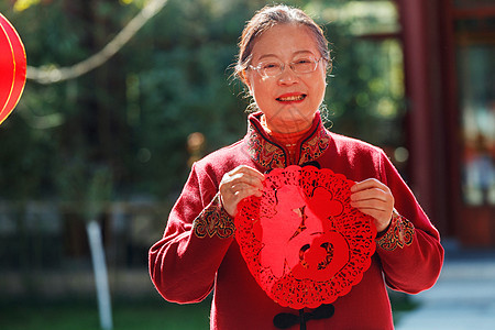 老年女人手拿窗花庆祝新年图片