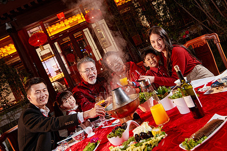 东方家庭在中式庭院内干杯庆祝新年图片