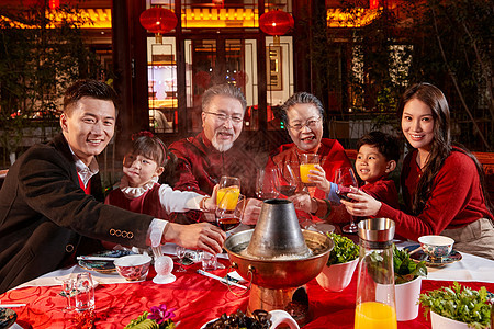 东方家庭在中式庭院内干杯庆祝新年图片