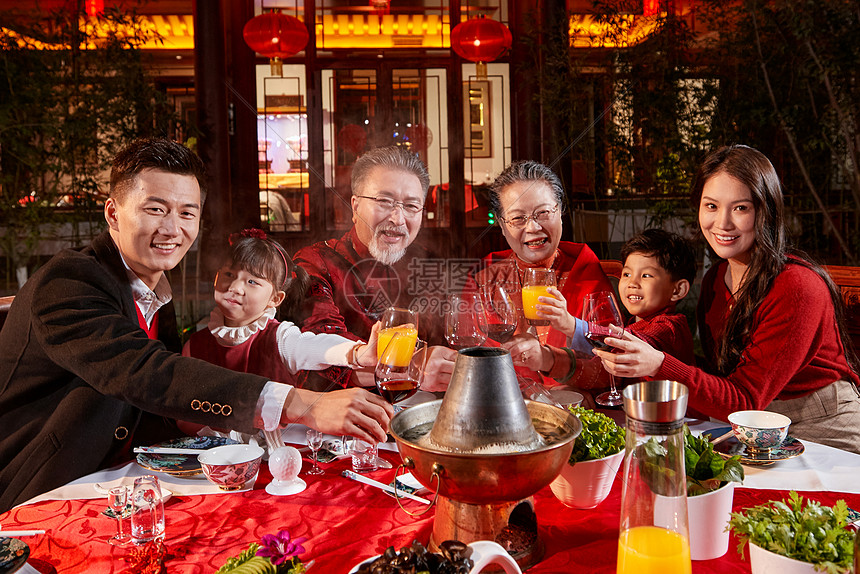 东方家庭在中式庭院内干杯庆祝新年图片