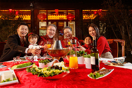 东方家庭在中式庭院内干杯庆祝新年高清图片