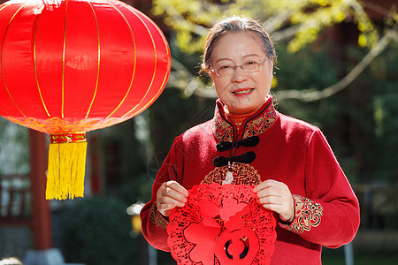 老年女人手拿窗花庆祝新年图片