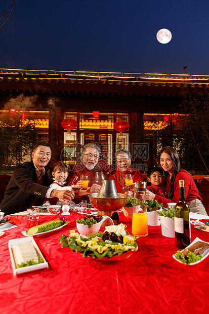 东方家庭在中式庭院内干杯庆祝新年图片