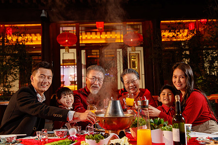 东方家庭在中式庭院内干杯庆祝新年图片