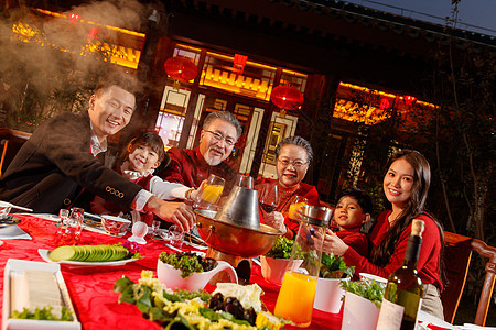 东方家庭在中式庭院内干杯庆祝新年图片