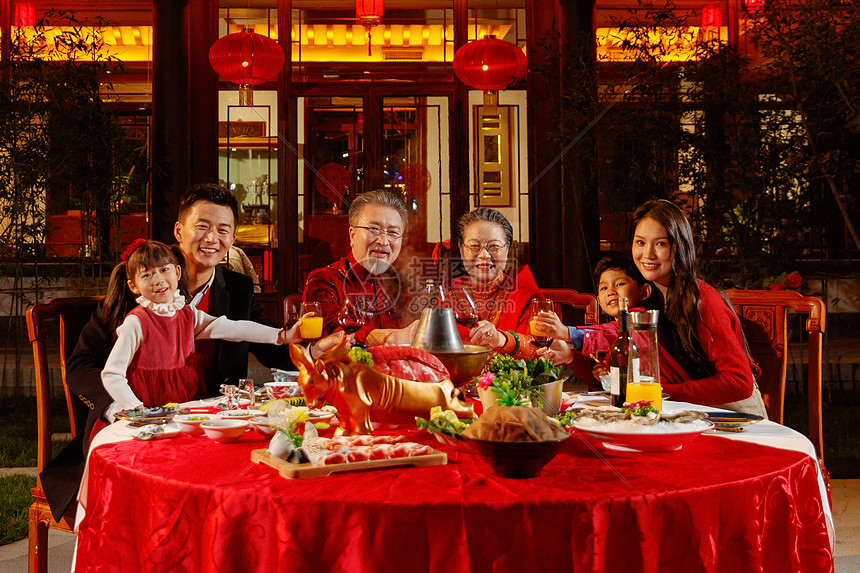 东方家庭在中式庭院内干杯庆祝新年图片