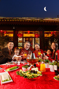 东方家庭在中式庭院内干杯庆祝新年图片