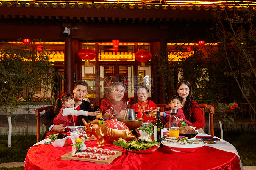 东方家庭在中式庭院内干杯庆祝新年图片