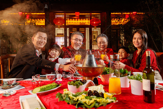 东方家庭在中式庭院内干杯庆祝新年图片