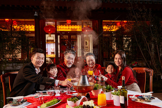 东方家庭在中式庭院内干杯庆祝新年图片